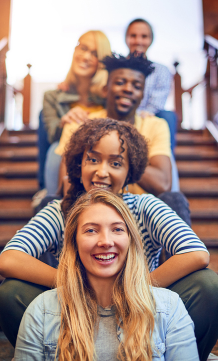 college students sitting in a row on steps