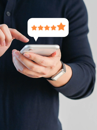 Person holding smart phone and leaving a 5 Wells Trust Google review