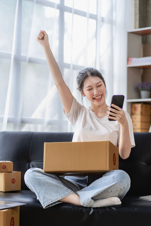 happy woman on phone with fist in the air